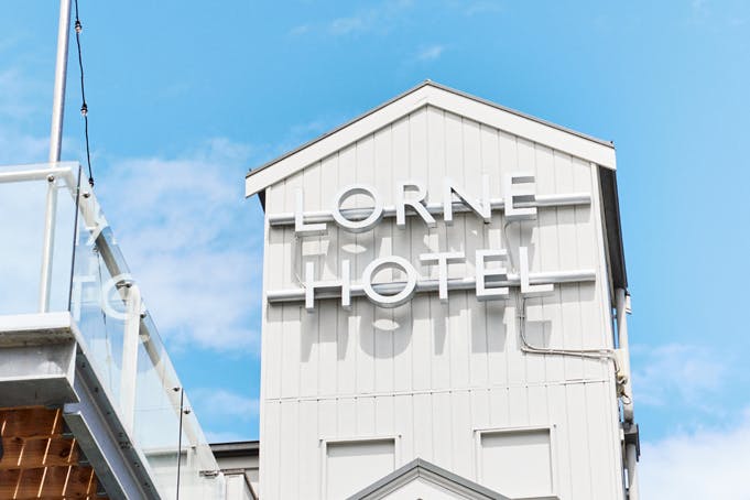 A large white building tower with blue skies in the background.